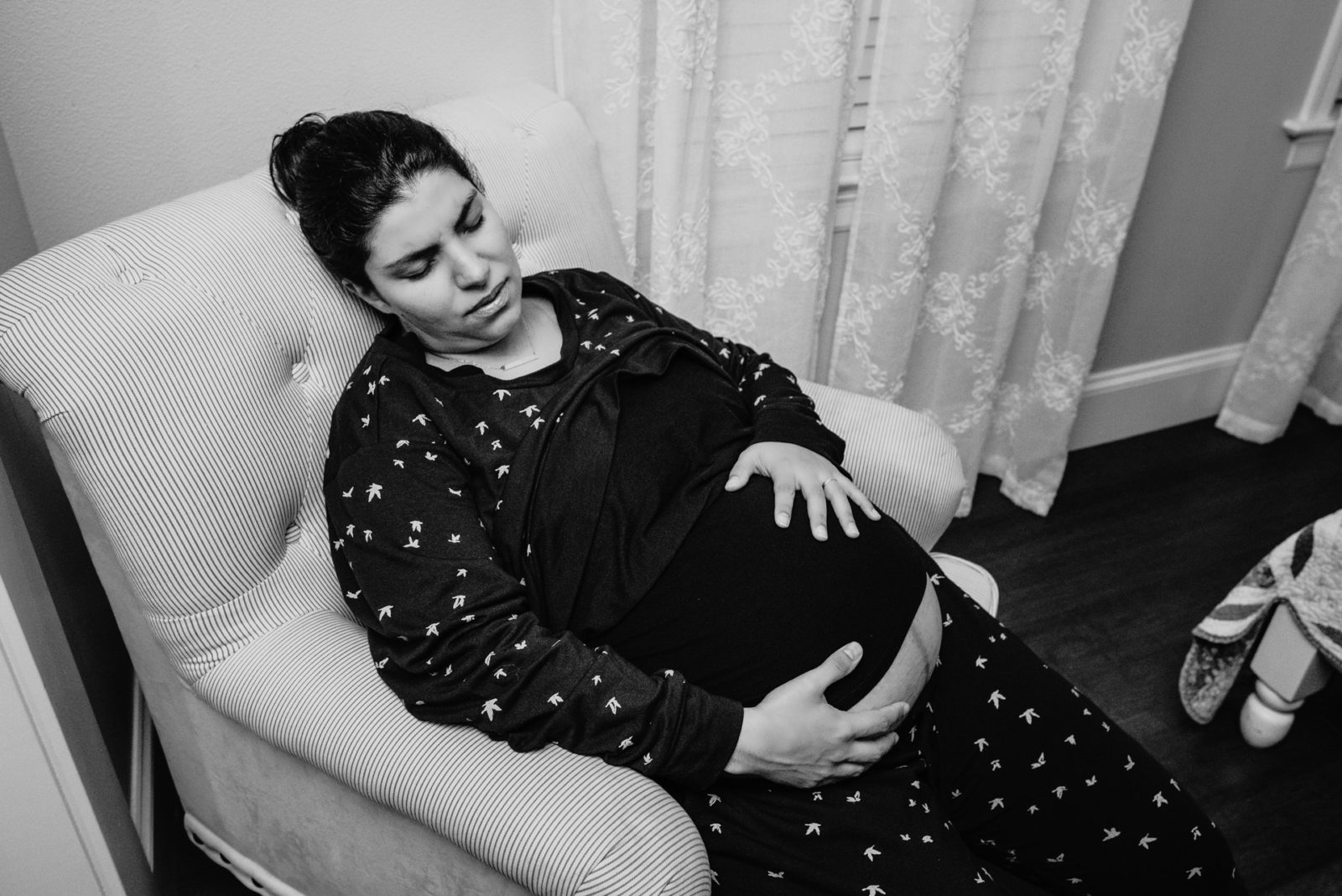 mother holds her belly during a contraction