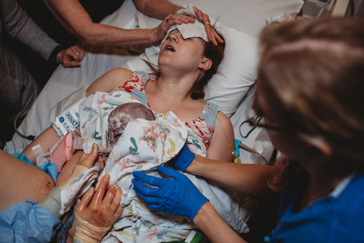 newborn baby covered in vernix is placed on mother's chest immediately after birth