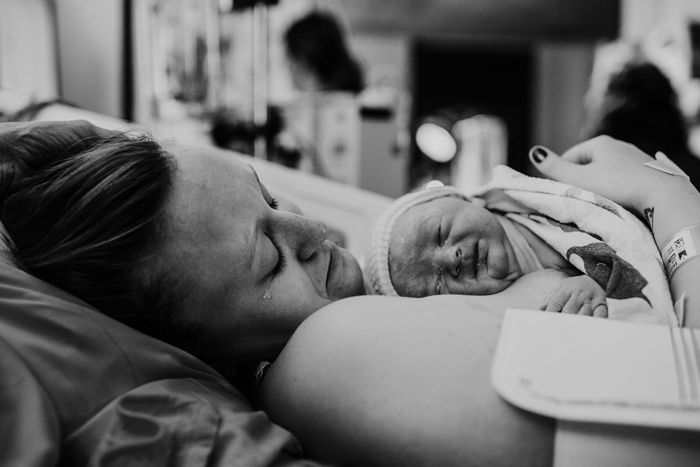 a tear rolls down mom's cheek as she looks down at her baby born at Good Sam hospital in Portland