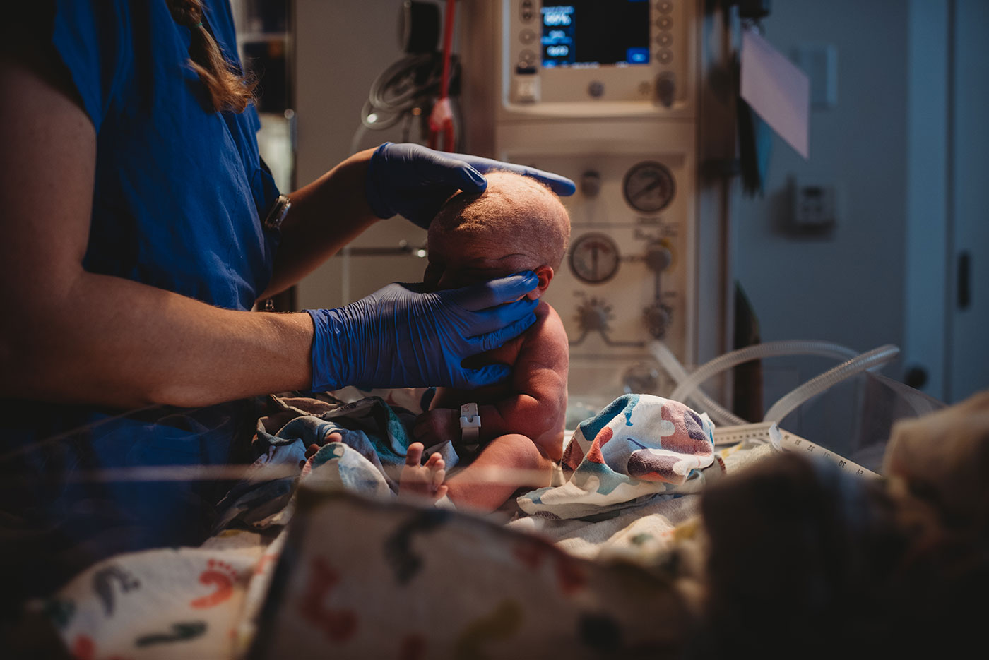 baby nurse feels newborn's soft-spot during his newborn exam after birth
