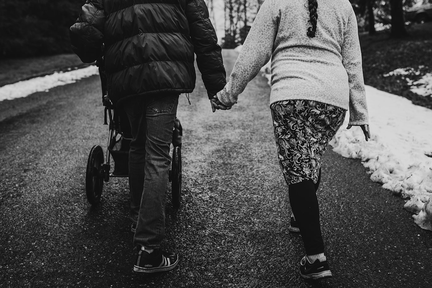 husband and wife hold hands while on a walk to kickstart contractions
