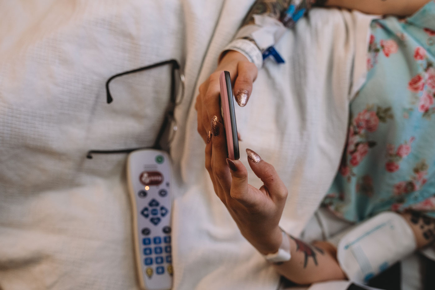 mom's hands texting on her phone in the hospital bed during labor