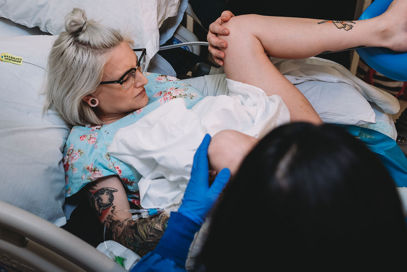 mom grabs her knees while pushing during childbirth in Portland