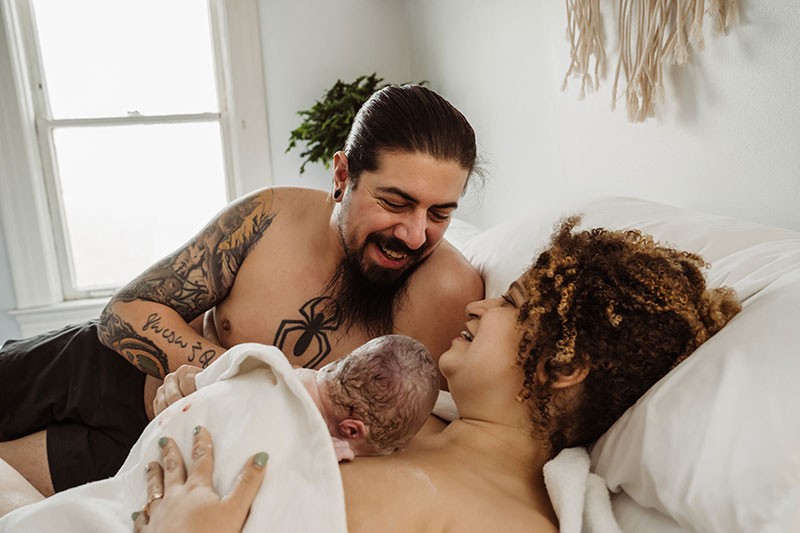 Parents smiling after birth by Natalie Broders Photography